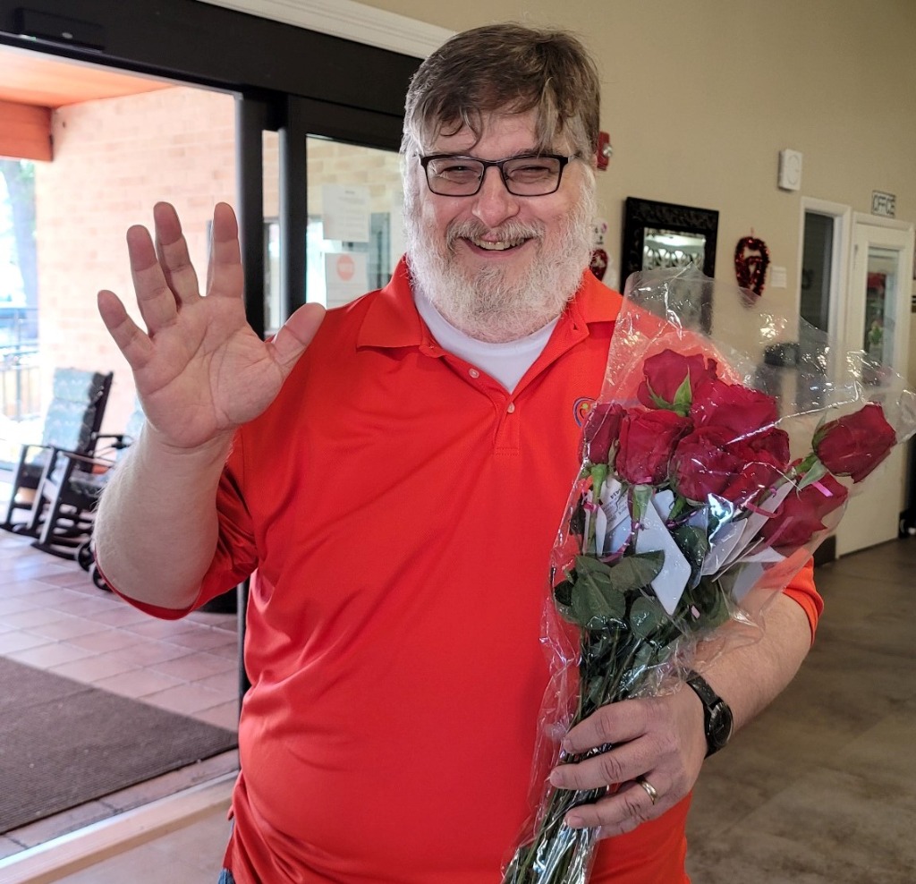 Mark Lyne handing out red roses to residents at The Clairmont Austin